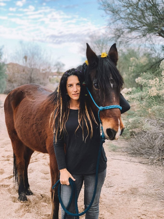 woman standing in front of brown horse