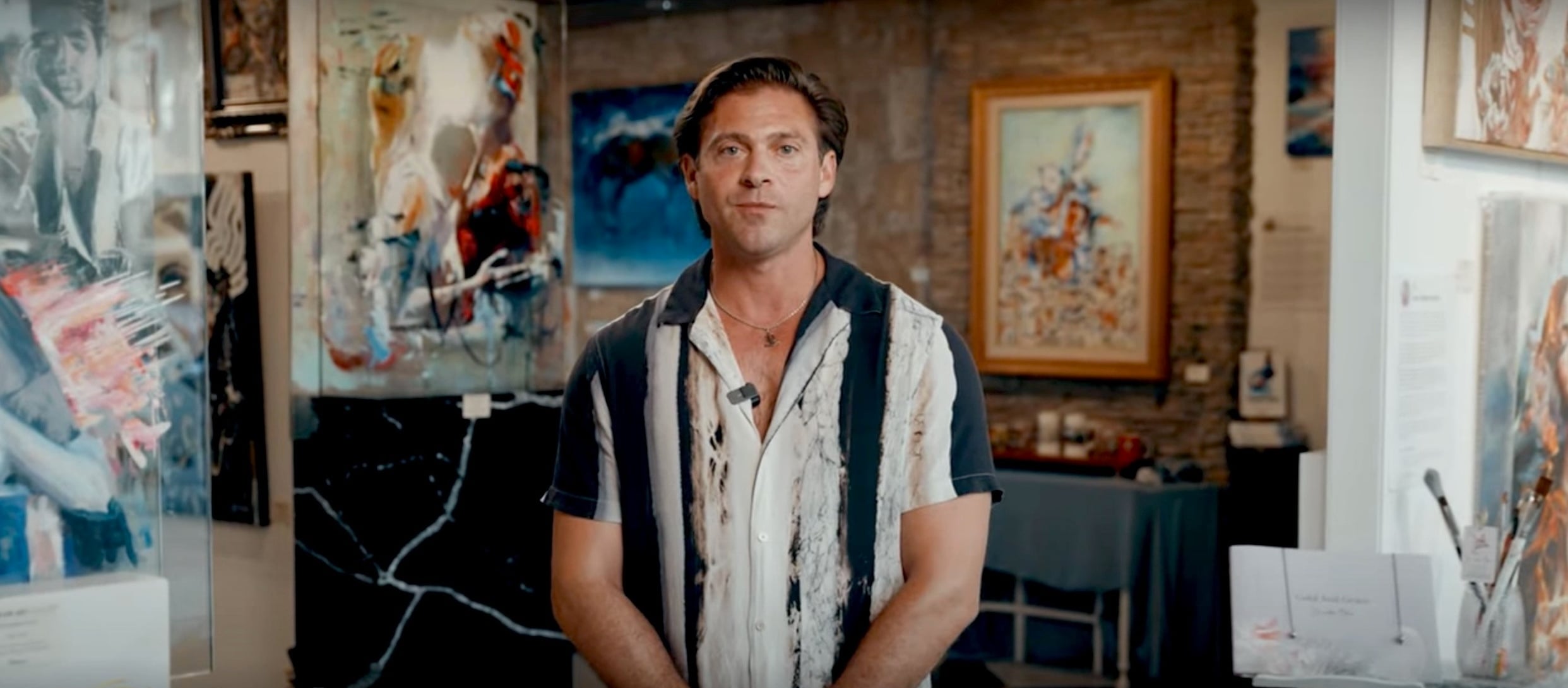 Man standing in gallery with bowling shirt style shirt