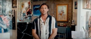 Man standing in gallery with bowling shirt style shirt