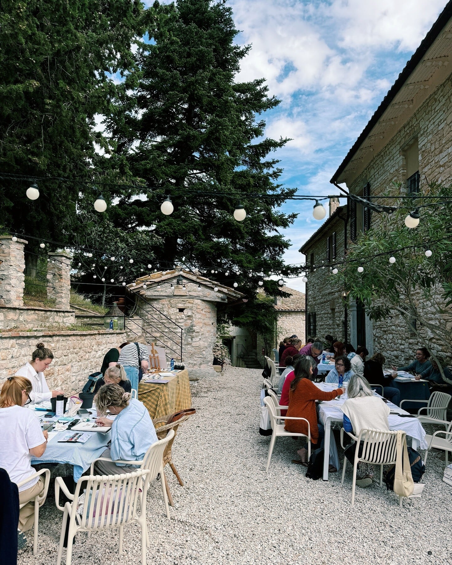 People sitting at tables in European environment in courtyard