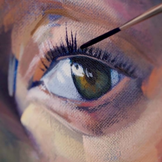 painting with brush painting black eye lashes  on green eyeball