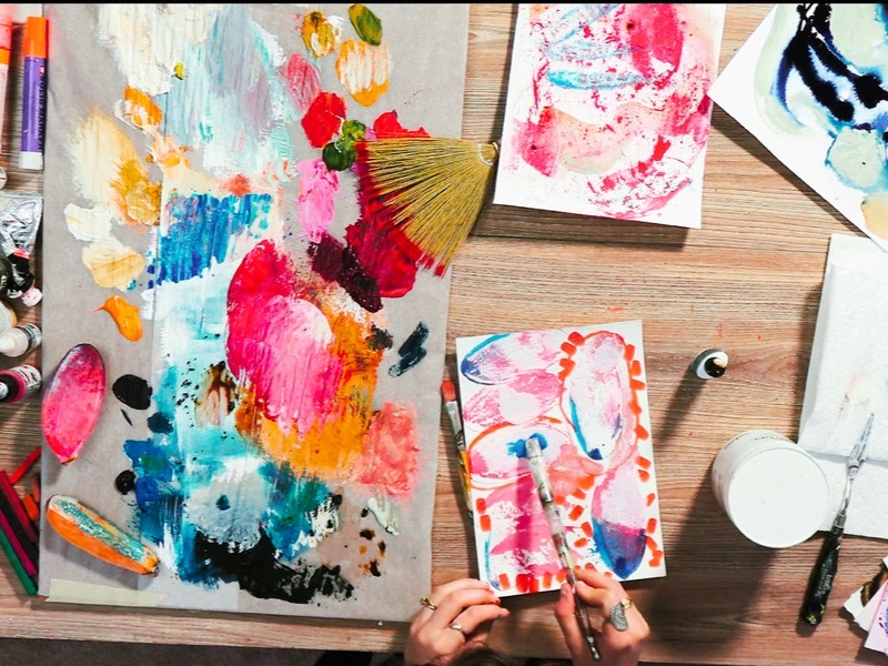 Overhead desk with small bright watercolor art hand painting