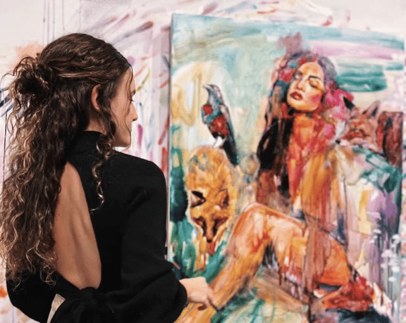 girl in black dress painting a figure orange teal purple