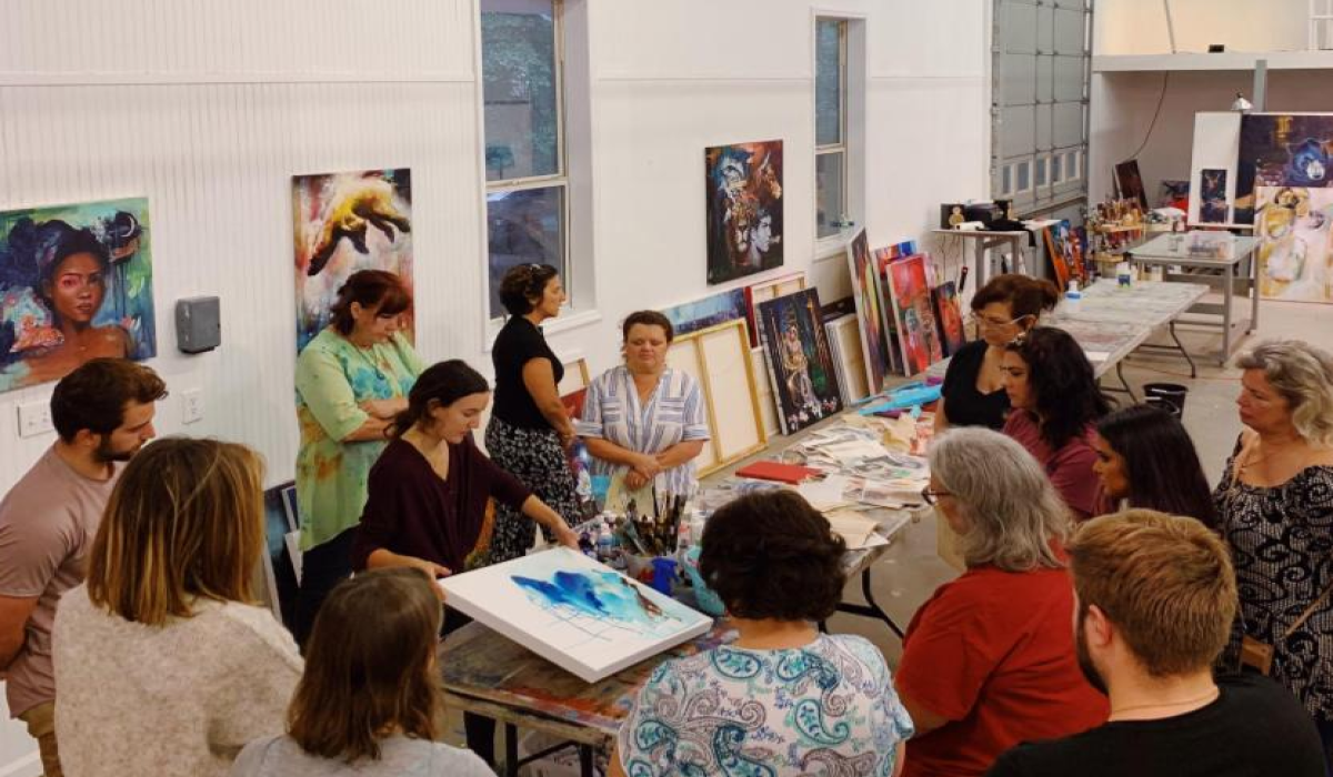 group of women with people standing around artwork