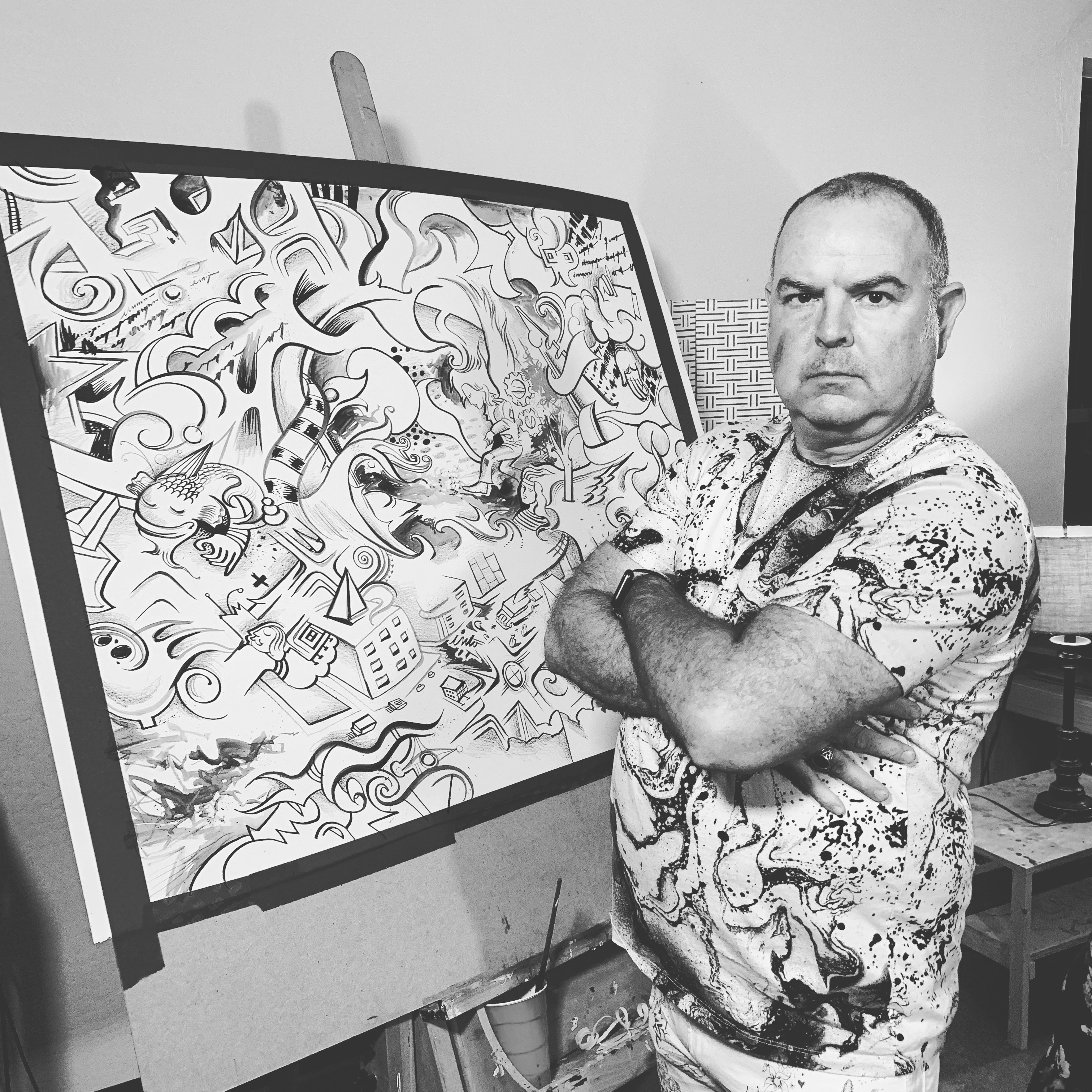 man standing in front of black and white art paper drawing