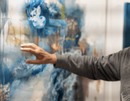hand showing a blue and tan painting 