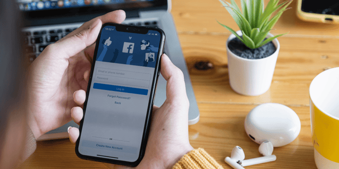 han dholding black phone liiking at screen of Facebook