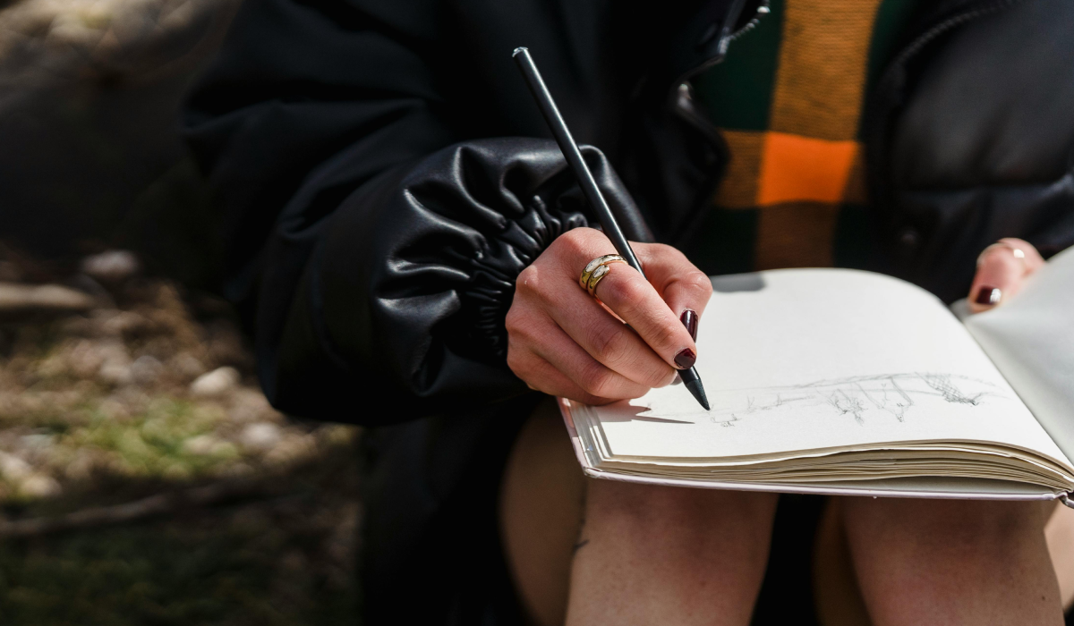 Woman painting outside in hat